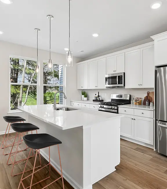 Kitchen with white cabinetry and pendant lighting